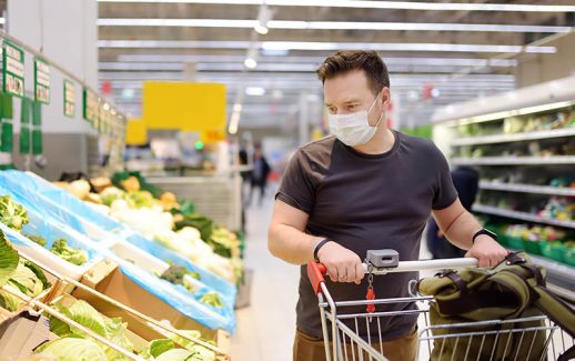 Homem faz compras em supermercado com máscara para se proteger da pandemia de coronavírus