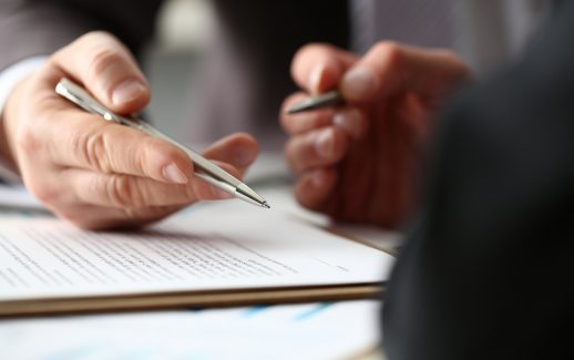 Dois empresários alinhando e assinando contrato