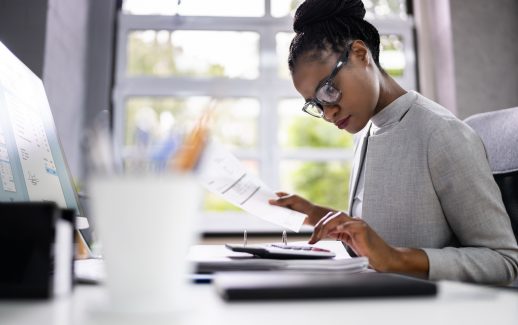 Mulher analisando contas manualmente