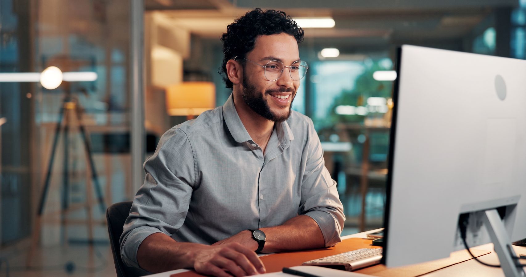 Profissional sorrindo enquanto trabalha no computador