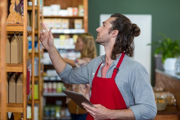 Homem em um supermercado, cuidando da empresa a fim de reduzir prejuízos na empresa.